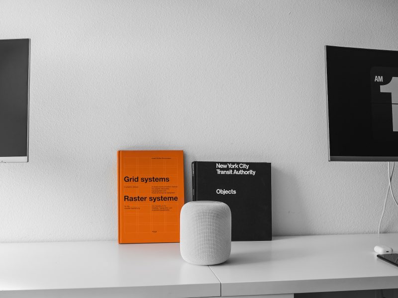 White desk with orange and black books leaning on wall